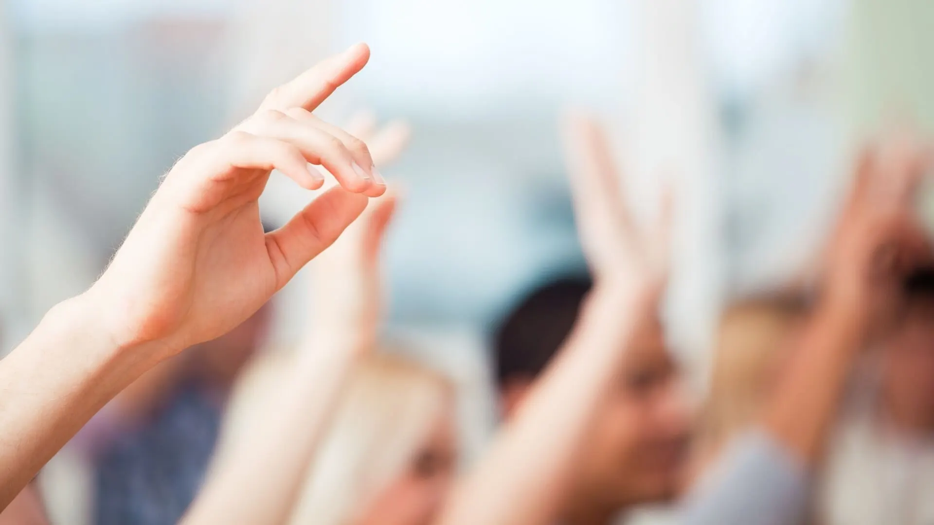 Leerlingen steken hun hand op tijdens de les